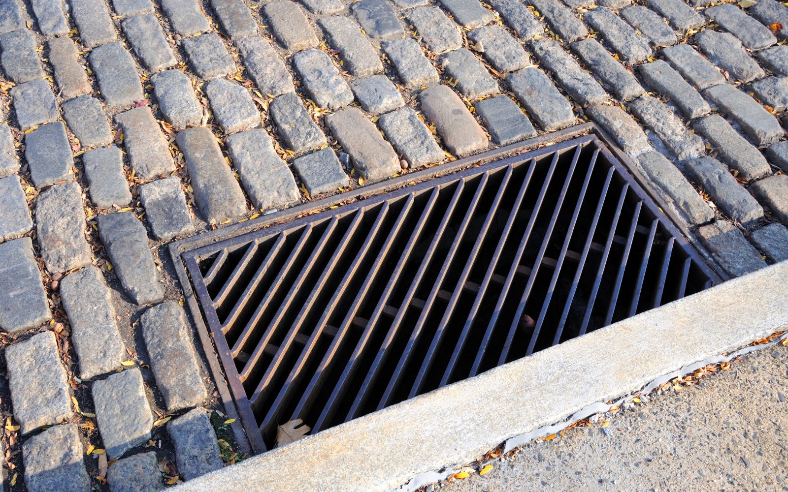 Catch basin drainage installation with grate collecting runoff and directing water into underground drainage system