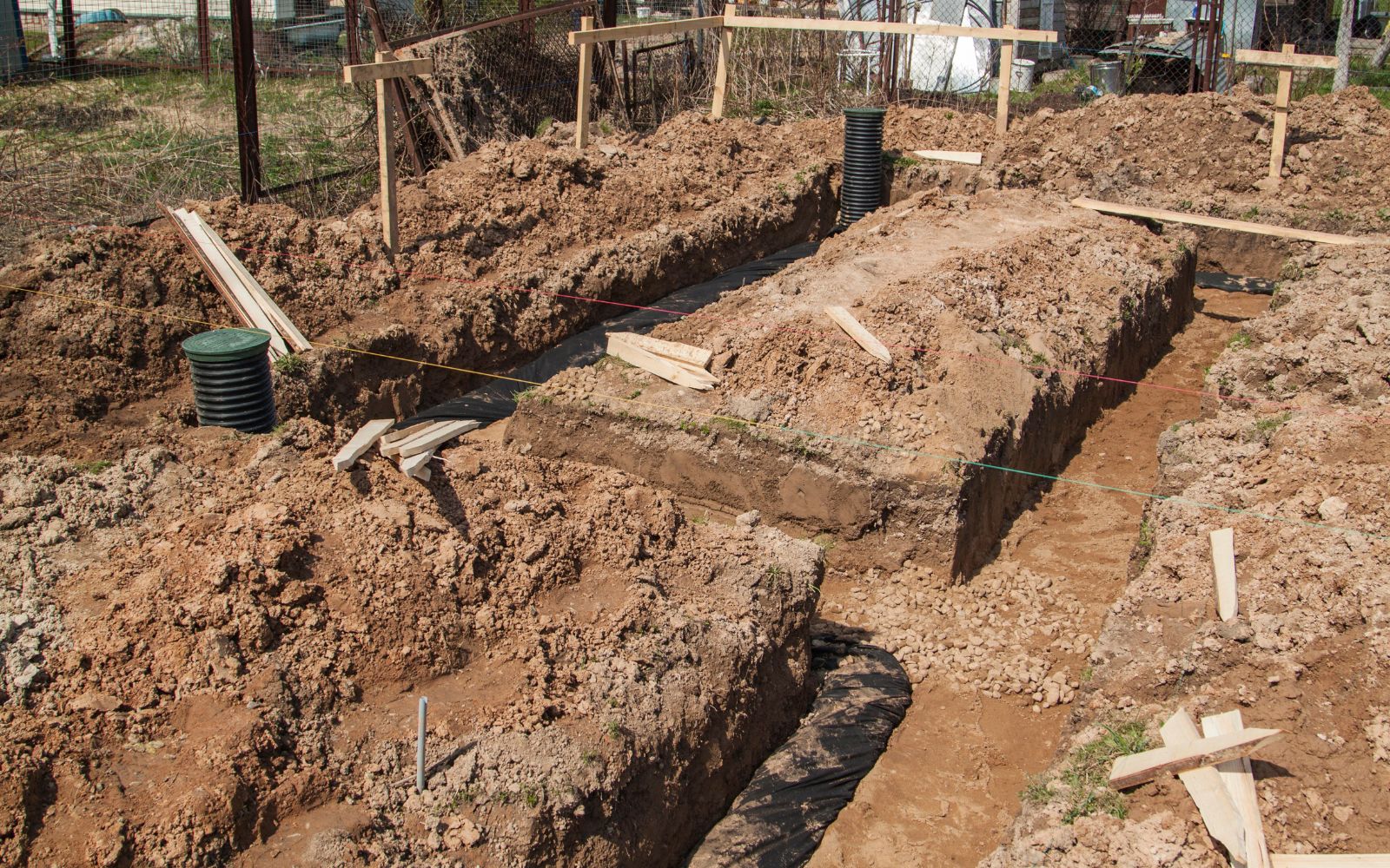 Engineered property drainage solution with trench drains and rock bed channel guiding water flow.