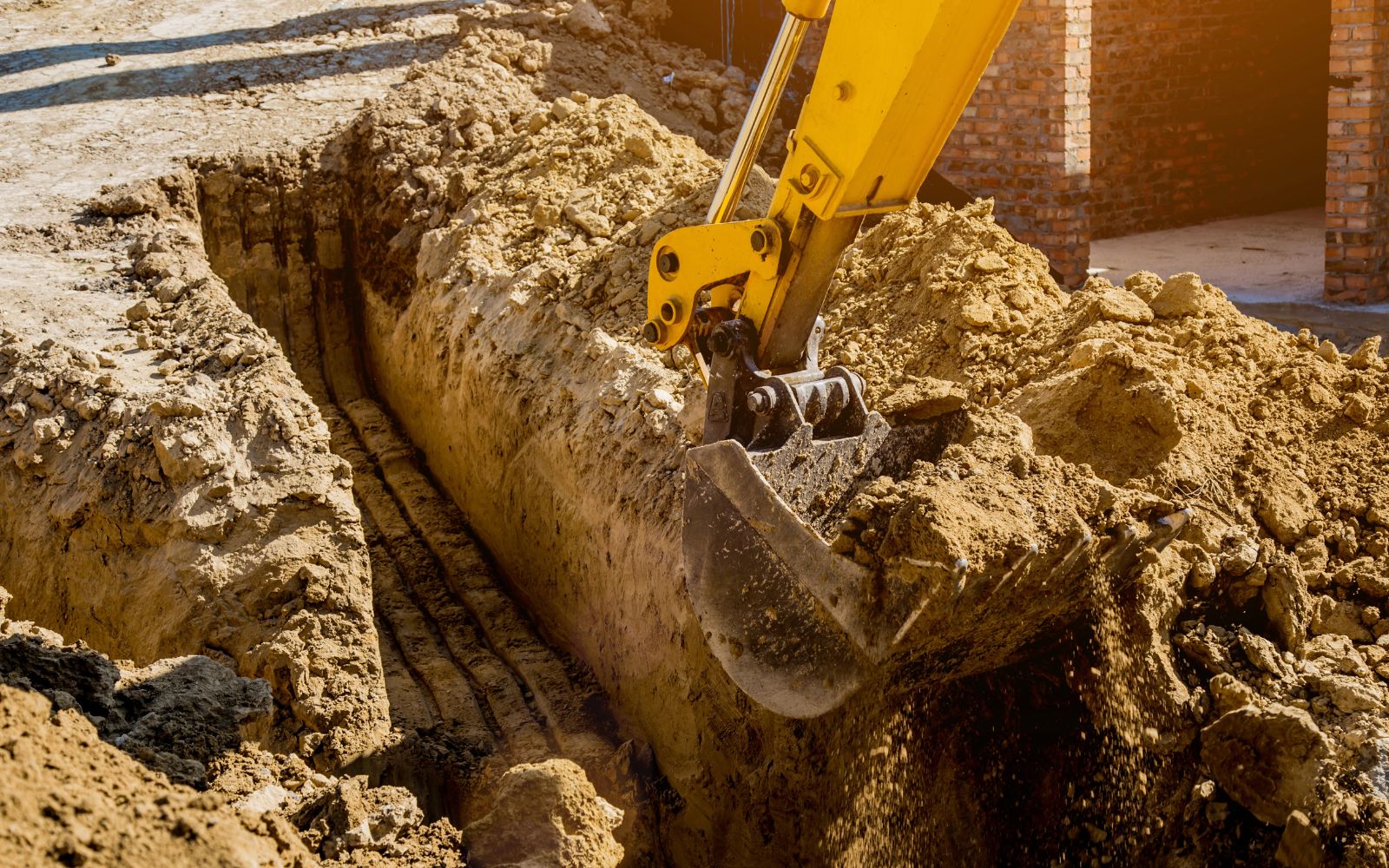 Excavator performing earthmoving and ground removal on a site for construction preparation