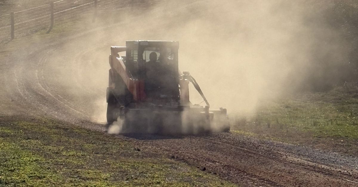 Professional gravel driveway repair and grading in progress using a Kubota compact track loader by Ground Truth Land Pros